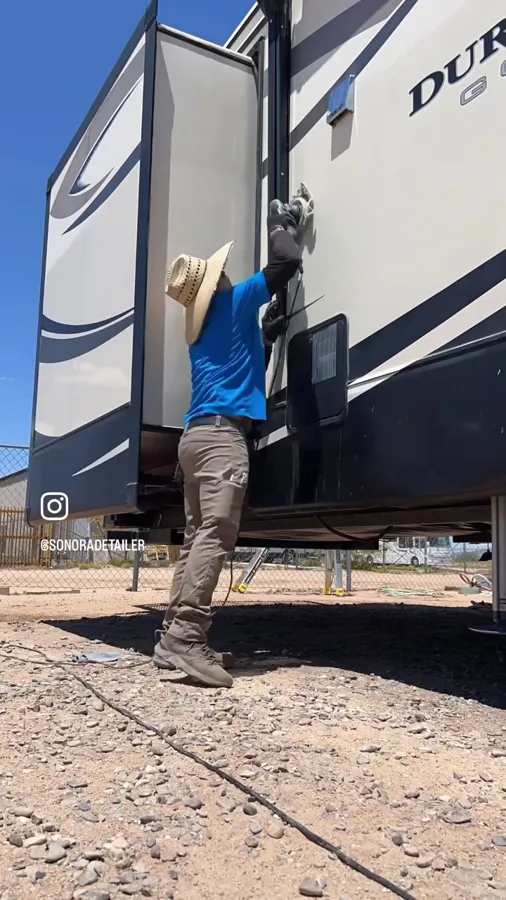 Ramon hand washing the slide-out on a travel trailer